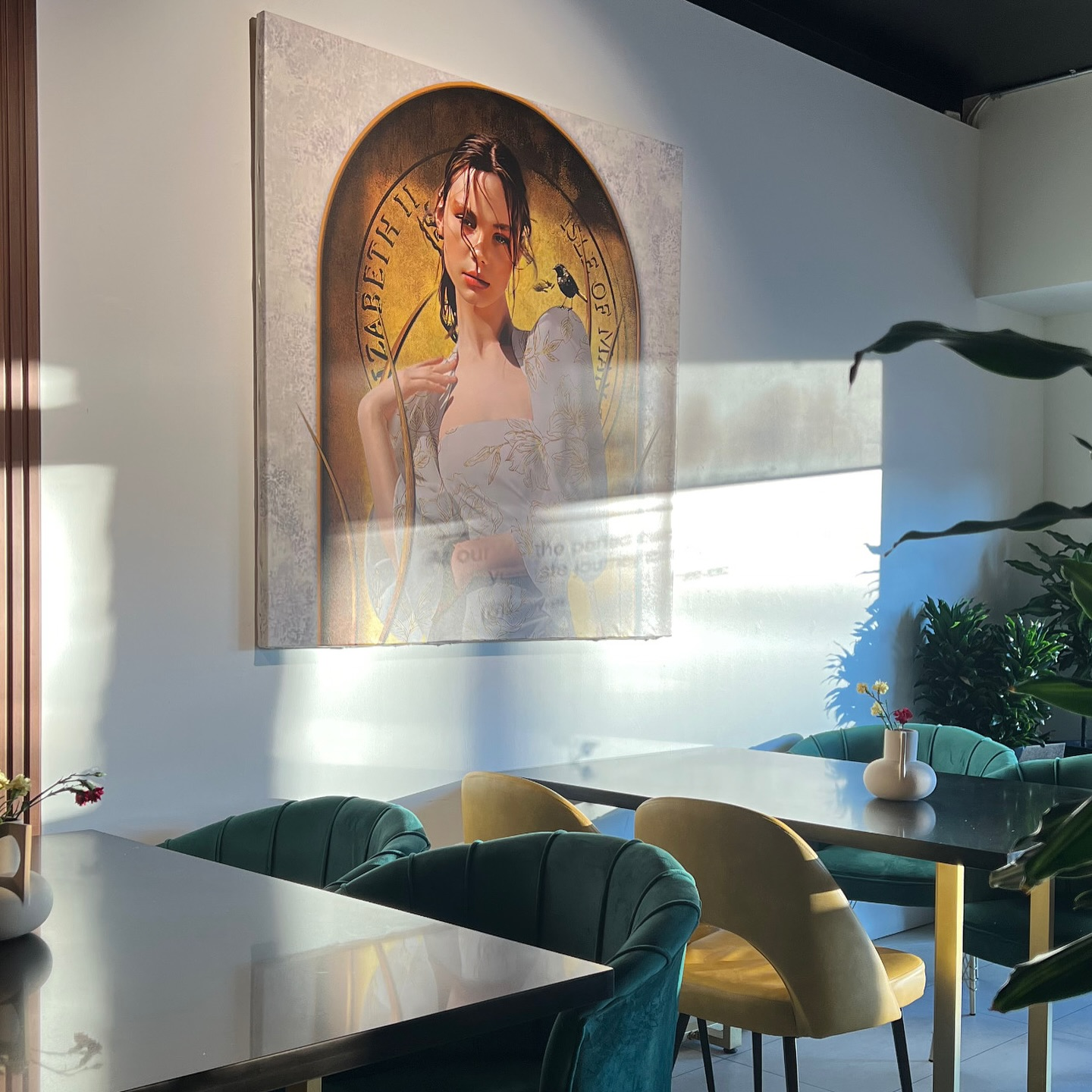 M&A Café interior featuring elegant teal velvet seating, vintage artwork, and warm ambient lighting